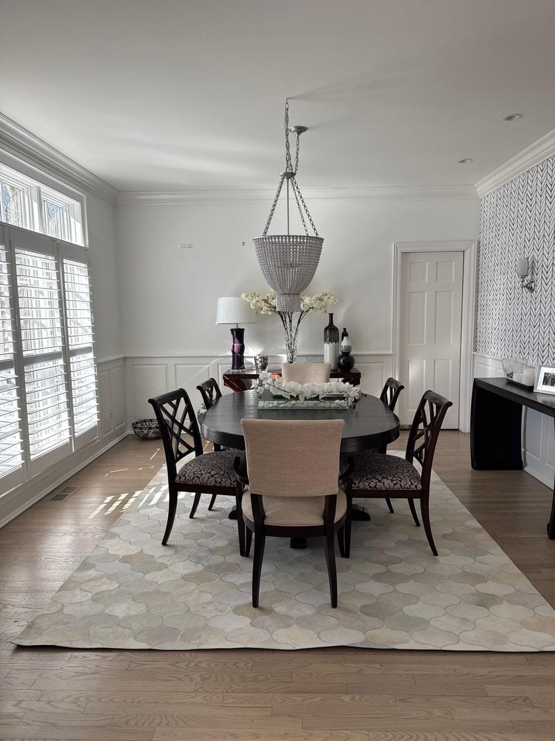 Formal dining room with a chandelier, an oval table and a patterned rug