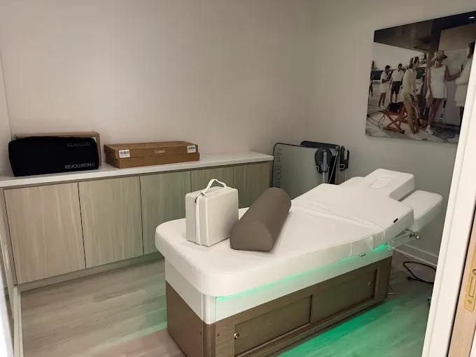 Treatment room with a padded table, cabinets and soft lighting
